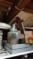 Photo of an old paint sprayer with attached metal canister showing signs of wear and oxidation.