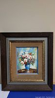 Frontal photo showing entire framed small painting of flowers in blue vase, capturing the multi-layered frame and painting detail.