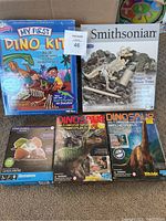 Five kids excavation kits arranged on floor showing the front packaging of each kit with colorful dinosaur and gemstone illustrations.