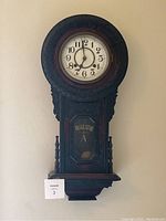 Front view of the antique wooden Seikosha regulator wall clock showing carved detailing and "REGULATOR A" label.