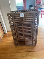 Side view of the antique wooden chicken coop showing the wooden slat construction and worn condition.