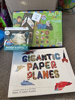 Photo showing boxed 179-piece Art 101 art set, Design-A-Vinyl Poo Emoji kit, Gigantic Paper Planes kit