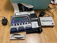 Photo of all items together including Digitech RP300A guitar processor, Audiosport Quatro audio interface, Boss CT-6 tuner, Sound Addict microphone and manual on wooden floor.