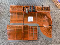 Top view of assembled orange transparent toy skate park ramps and sections on carpeted floor