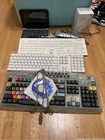 Overview of all keyboards including Apple Bluetooth keyboard, Macally keyboard, EZ Keyboard with driver CD and USB cable, Contour ShuttlePro USB controller, Mini iPad with keyboard, and TP-Link Wi-Fi range extender box