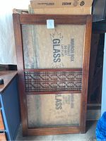 Front view of one Korean wooden framed door or window with glass panels and an intricate wood lattice center section.