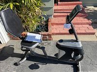 Full side view of the Fitness Reality recumbent exercise bike showing the seat, pedals, and base frame.