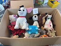 Box filled with over 20 stuffed animals featuring Dalmatian dog, Hello Kitty, Snoopy, spotted dog, and other plush toys packed tightly.