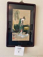 Framed vintage Japanese painting showing woman bathing in water with pail and foliage, with overall view of frame and artwork.