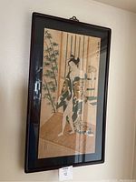 Framed Japanese painting of two women bathing viewed from the front, showing the entire artwork and frame.