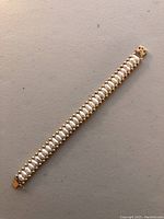 Full length top-down image of the freshwater pearl and gold bead bracelet showing the entire piece laid flat.