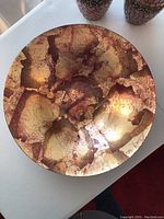 Top view of large abstract decorative bowl showing gold and burgundy colors with crackled appearance.