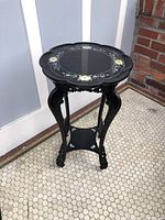 Full angle showing the table top with mother of pearl floral inlay and curved carved legs.