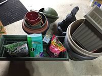 Overall view of assorted gardening items including planters, decorative rabbits, and bags of gardening products.