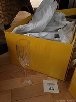 Single Lenox Serene Champagne Goblet displayed in front of yellow box with tissue paper inside