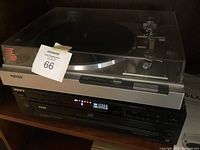 Sony turntable record player with transparent dust cover on top of 5-disc CD player unit