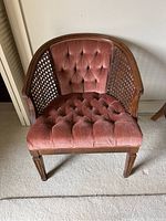Front view of the chair showing tufted upholstery and cane backrest.