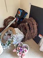 Overall lot showing 7 grapevine wreaths, straw wreath, floral paper roll, foam board, and bags.