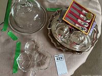 Photo showing glass cheese dome and plate, three-section pickle server, set of four cheese knives, pen and pad, magnifying disc, and a polished silver-tone serving tray.