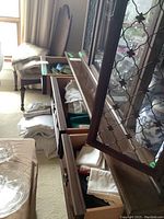 View of multiple drawers and surfaces holding folded tablecloths, napkins, and placemats inside furniture.