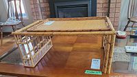 Full view of the bamboo and rattan breakfast tray sitting on a wooden table in a living room environment.