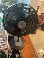 Full view of black Weatherworks floor fan showing cage guard, blades, and base.