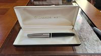 Parker 61 fountain pen displayed inside original case on a glass table.