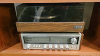 Photo showing the full audio set with the turntable on top and receiver below, capturing the setup and condition.