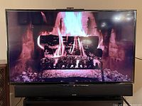 Samsung 48-inch LED TV displaying a fireplace video with a soundbar placed below it. The soundbar is not included in the sale per seller's note. Included remote is not visible in the photo.
