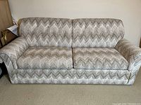 Sofa bed in standard seating position showing chevron patterned upholstery.