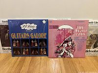 Front view of 101 Strings Plus Guitars Galore and My Fair Lady LP albums showing colorful illustrated album covers.