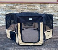 Front view of the Zuhucpts foldable portable pet playpen showing mesh door, tan canvas and black trim.