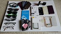 Overview image showing spread of items including sunglasses, iPhone cases, arm band, screen protector, and glasses on white background.