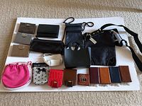 Photo showing collection of assorted wallets, key holders, pouches, and bags on white background