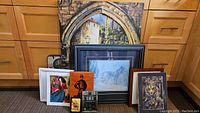 Overall view of the collection grouped on floor showing various framed and unframed wall art and plaques