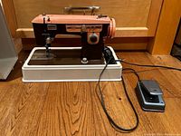Vintage Brother Charger 651 sewing machine on white base with attached power cord and foot pedal on wooden floor.