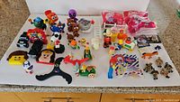 Wide view of assorted collectible toys including Dairy Queen Knight, McDonald's toys, Fraggle Rock cars, Fisher Price Little People and others