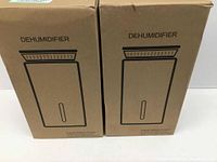 Two original cardboard boxes labeled 'DEHUMIDIFIER', side by side.