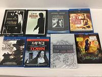Photo showing the full set of 8 Blu-ray movies arranged in two rows on a white surface, highlighting their covers for identification.