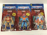 Front view of three packaged Masters of the Universe figures: Stratos, Faker, Sorceress