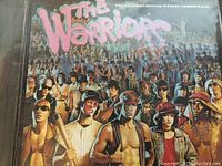 The Warriors soundtrack record cover showing a group of characters from the movie with title in stylized pink font.
