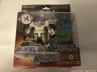 Front view of unopened Transformers Ghostbusters Ectotron Ecto-1 Megatron action figure in packaging, showing figure and accessories clearly.