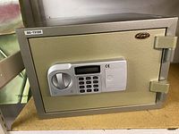 Front view of Brawn security safe showing locked door with electronic keypad and manual dial handle. Brawn logo on upper right.