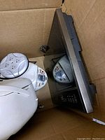 Box containing all items of the lot including the stainless appliance, white kettle, power strip, and water boiler.
