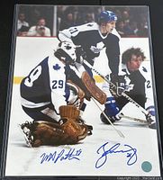 Lower half of photograph in plastic sleeve showing both blue ink signatures