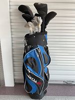Full view of blue and black Founders Club stand golf bag loaded with bubble-wrapped irons and neoprene headcovers