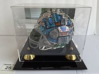 Front view of helmet sculpture inside acrylic display case on black base