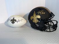 Helmet and football side by side on tabletop against white backdrop