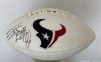 Close-up of JJ Watt's signature on the Houston Texans logo football panel.