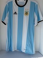 Front of light blue and white striped Argentina jersey hanging